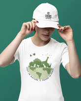 Person wearing a white t-shirt with a green graphic and a white cap on a green background